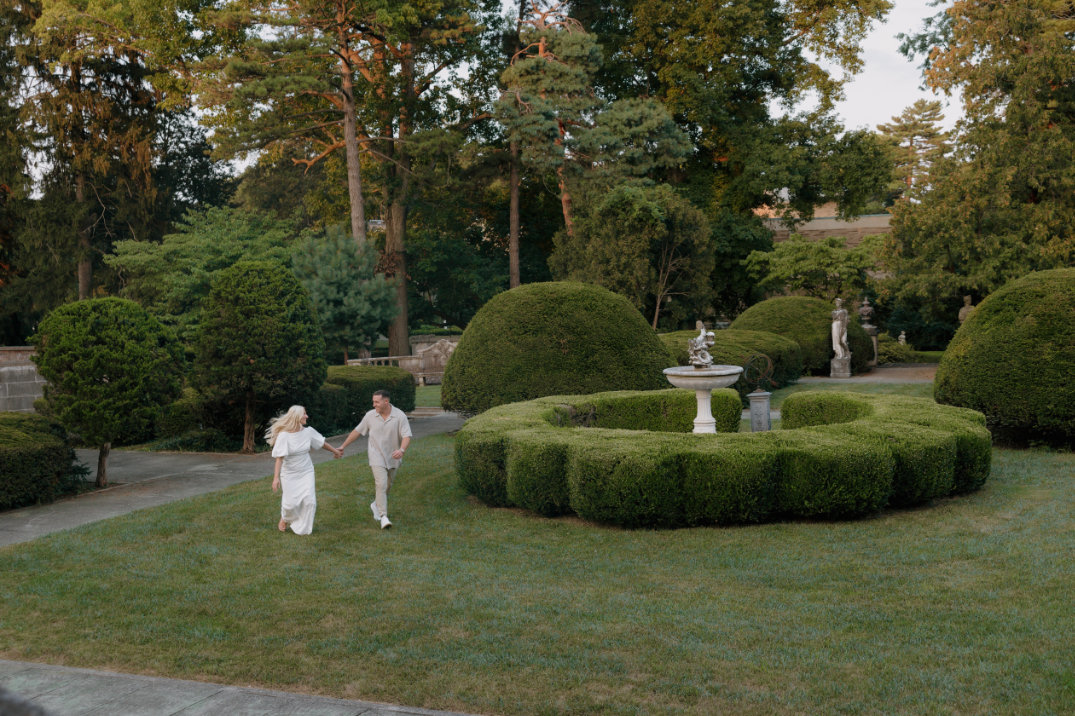 Wide garden view with the couple walking together in the distance, captured by Cincinnati, Ohio engagement photographer.