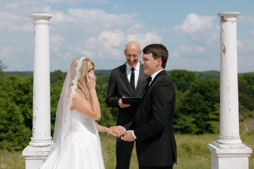 Intimate ceremony moment of the bride and groom holding hands during their vows