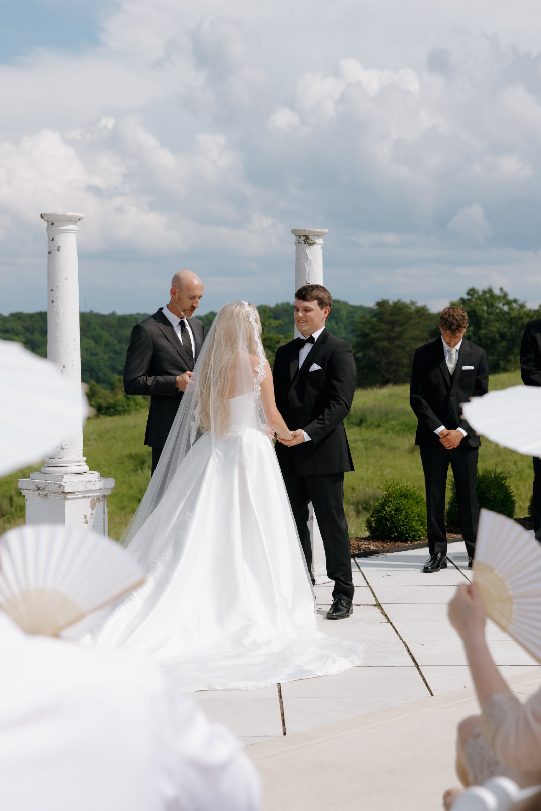 Shot of the outdoor wedding ceremony at The Seventy Five Venue in Hocking Hills, Ohio, with the bride and groom exchanging vows, photographed by Chloe Elizabeth Photography.