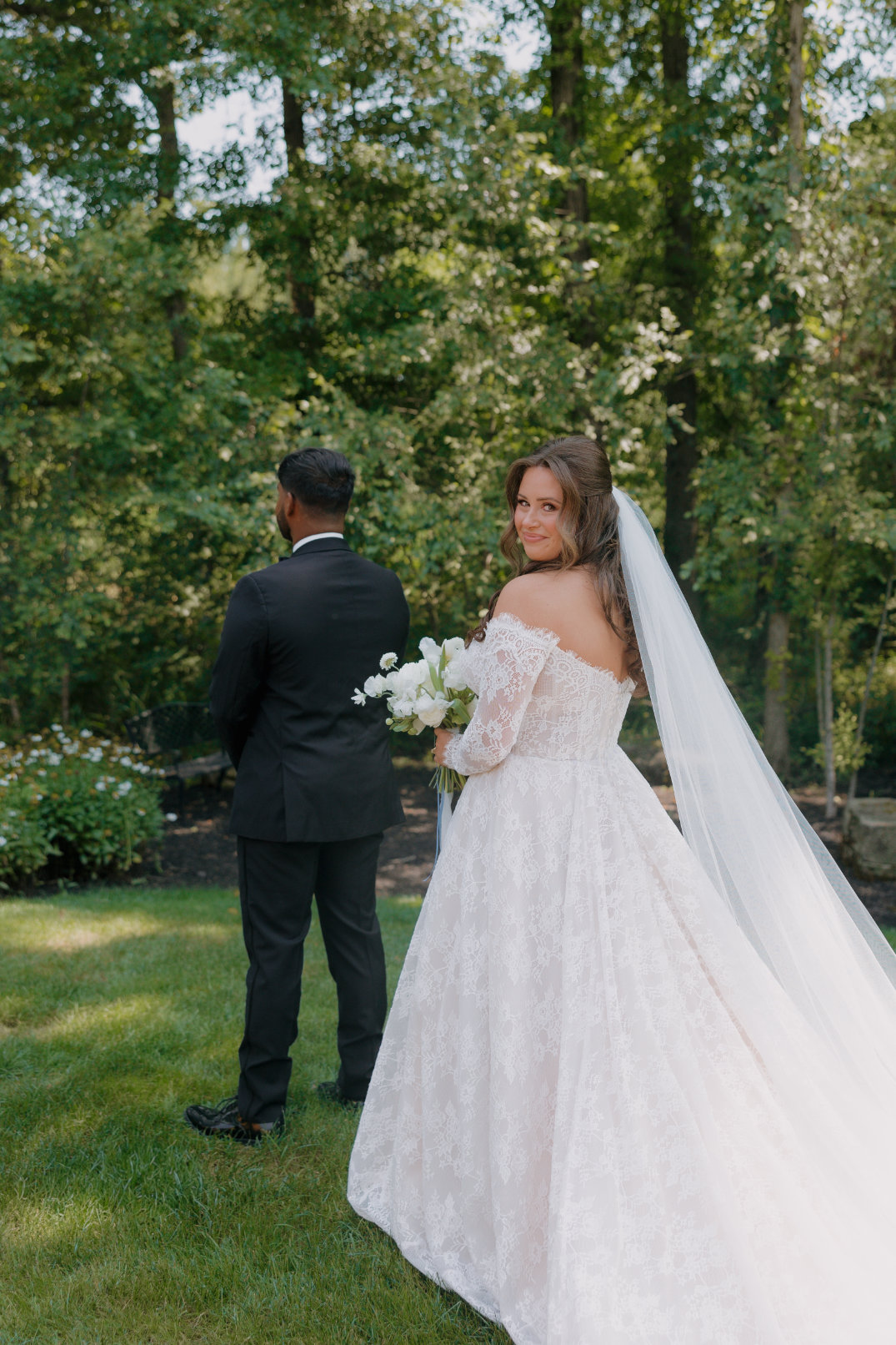 Bride approaching groom during the first look, surrounded by greenery in Columbus, Ohio.