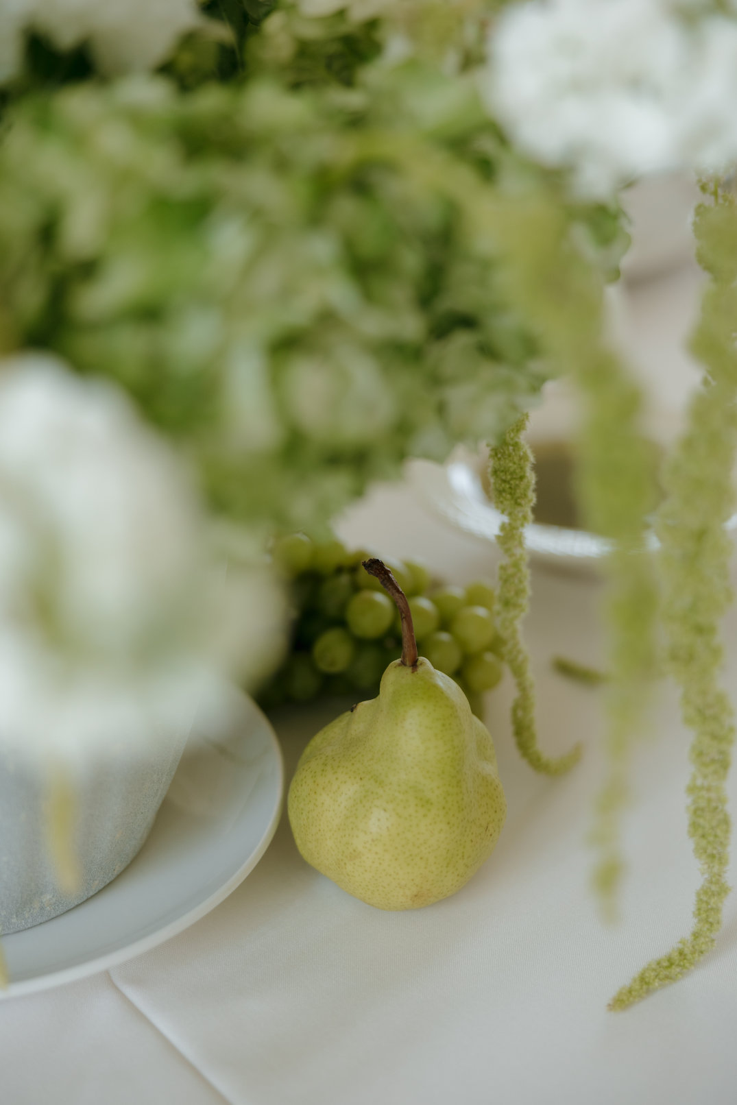 Close-up detail of table décor featuring fruit and florals styled for the reception.
