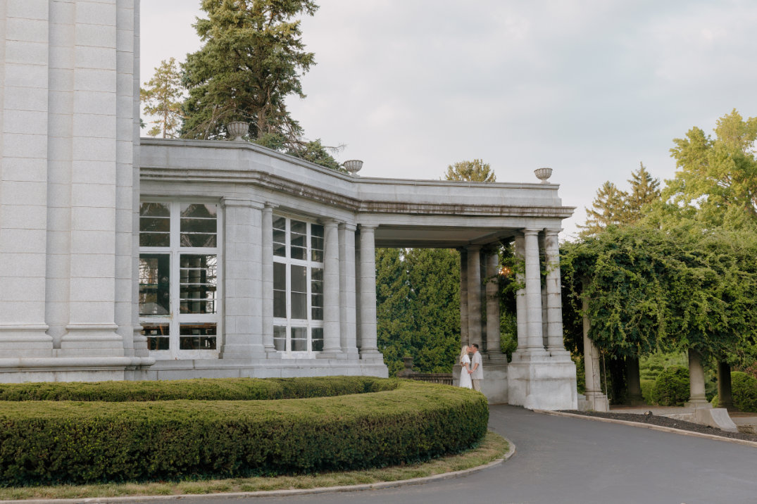 Exterior architectural view of a grand estate building with columns and greenery at Laurel Court, Cincinnati.