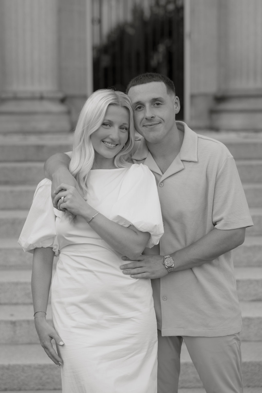 Black and white portrait of the couple standing close, framed tightly at the waist and shoulders.