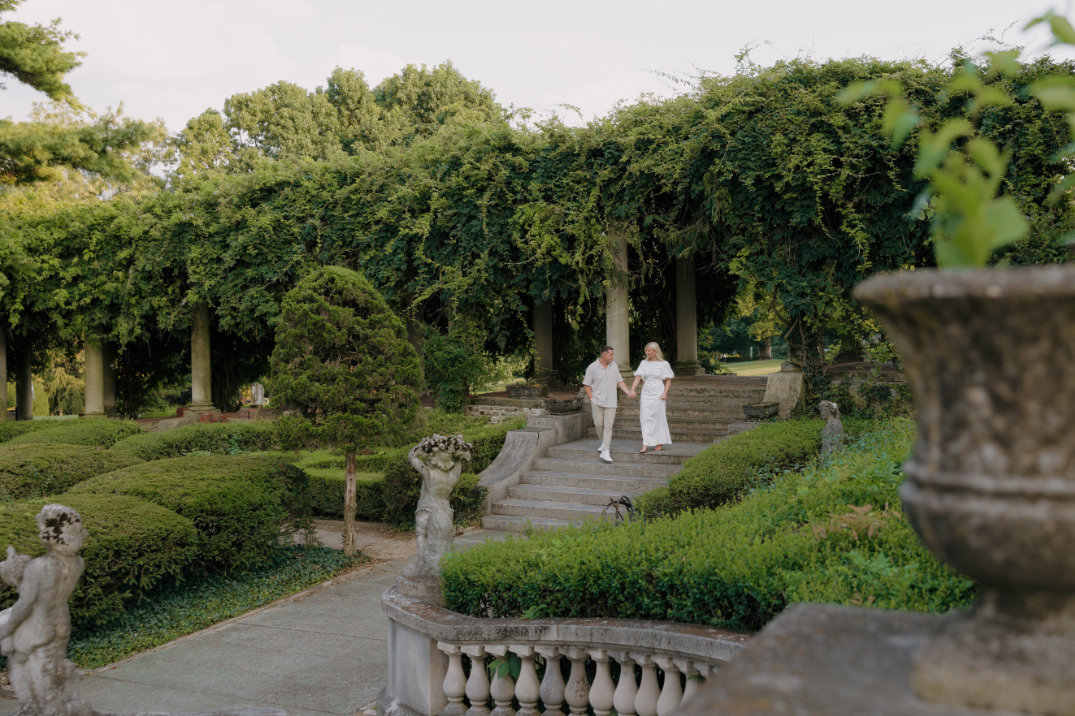 Wide garden view with manicured hedges and stone pathways, photographed during an engagement session by Cincinnati photographer.