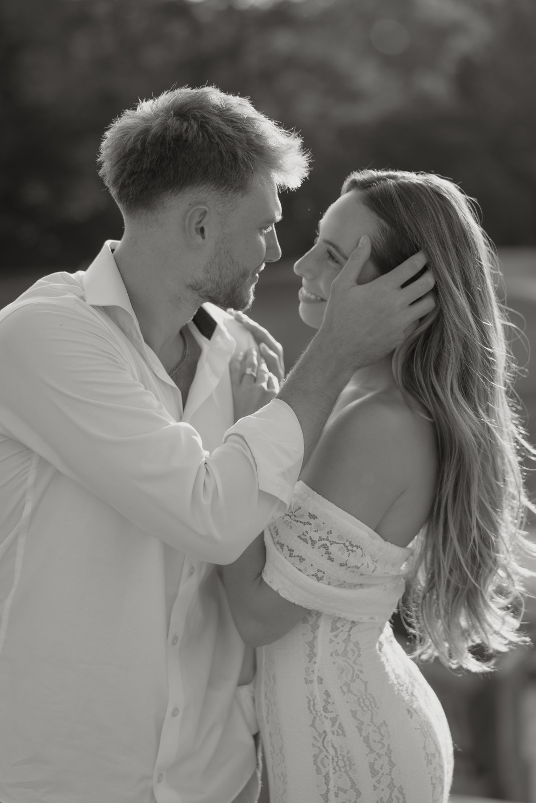 Black and white close-up of the couple holding each other's faces while about to kiss, photographed by Chloe Elizabeth Photography.