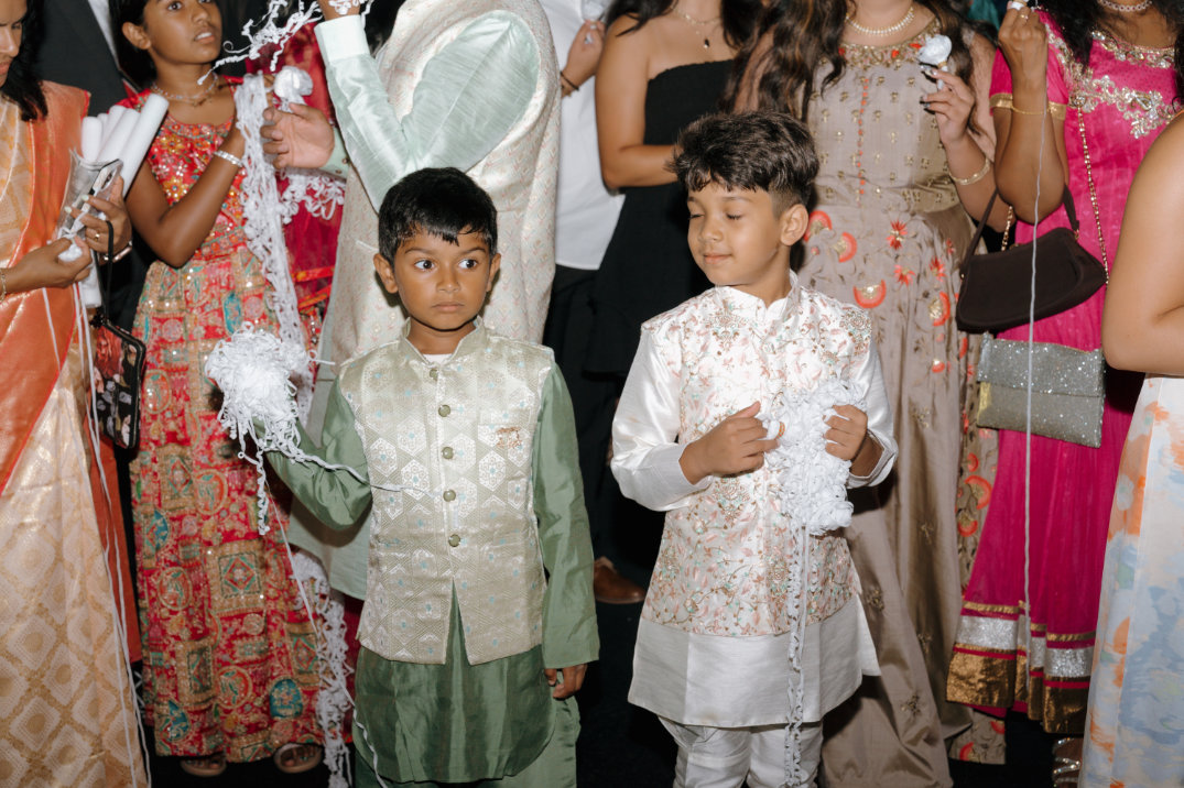 Children standing together during the celebration, dressed in formal attire.
