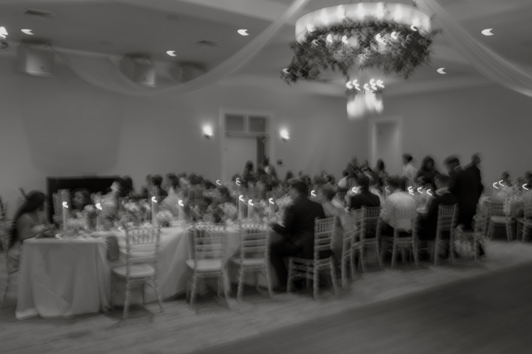 Wide interior view of the reception space with tables set and guests seated.