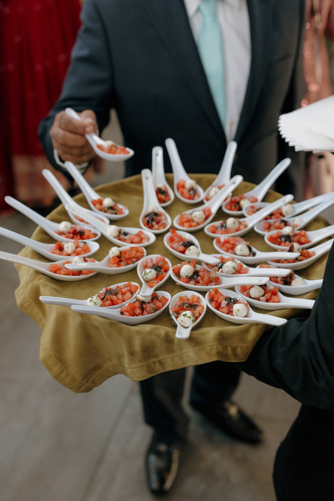 Server holding a tray of plated appetizers during cocktail hour.