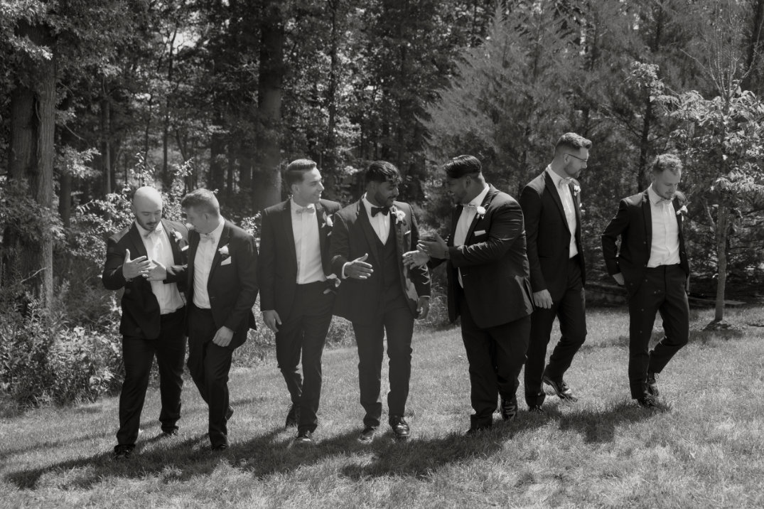 Black and white image of the wedding party walking together in a line.