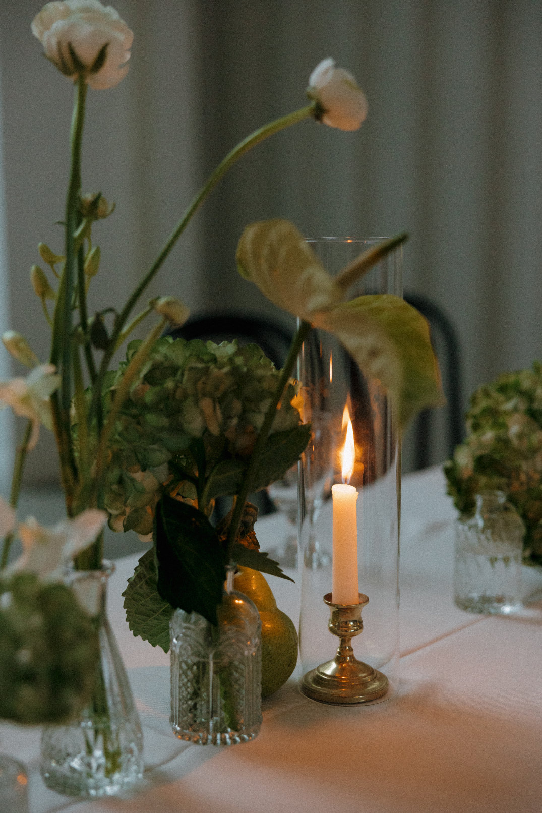 Moody reception detail featuring candlelight, greenery, and an intimate table setting.